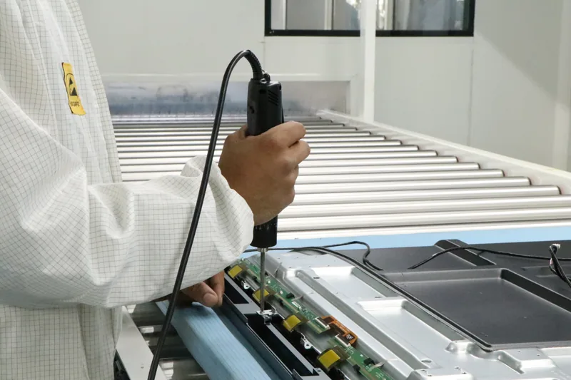 Technician precision-assembling a PCB display panel on StudynLearn's IFP manufacturing line